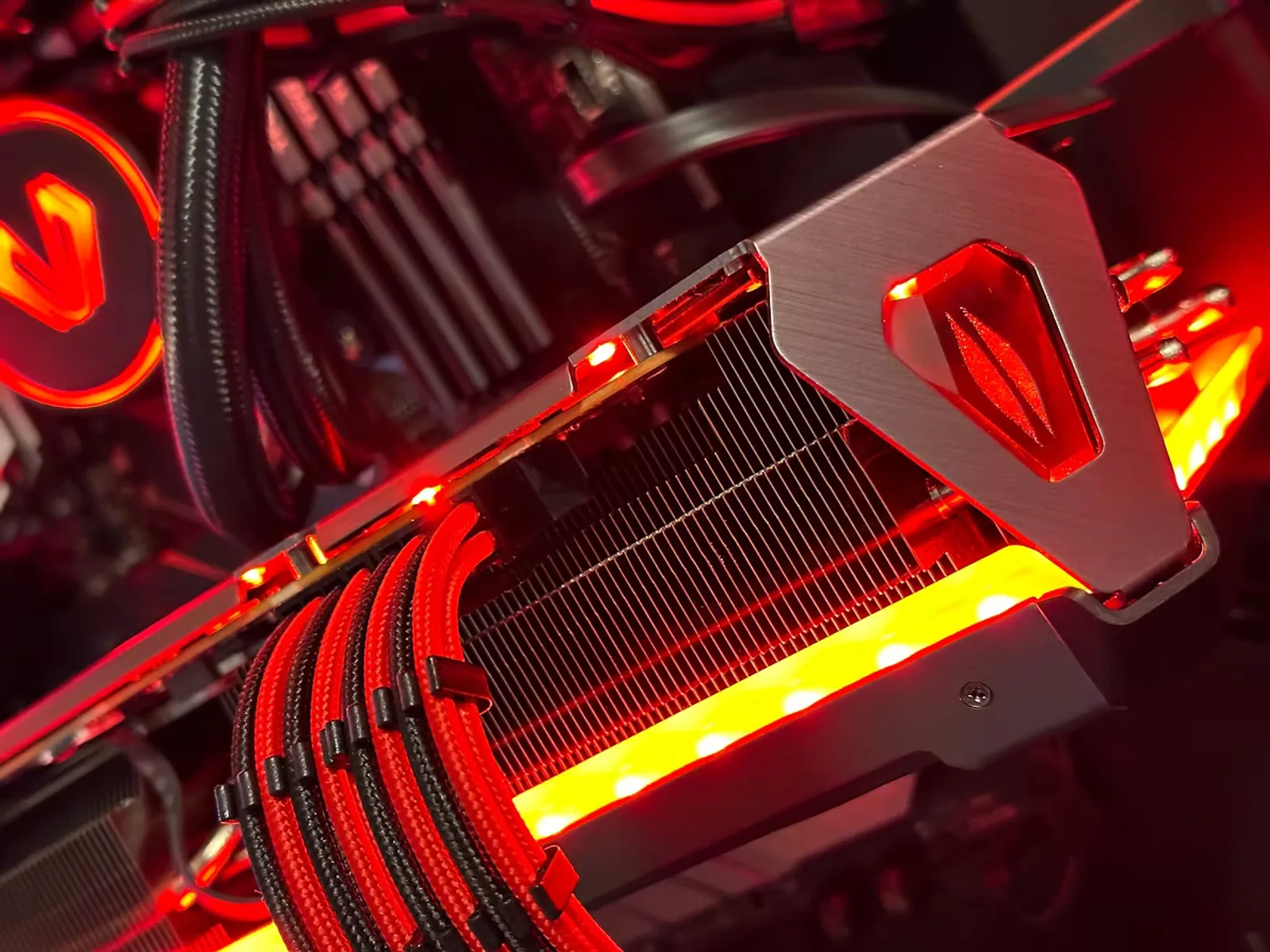 Red-lit gaming PC interior with an ROG graphics card heatsink and matching red sleeved cables