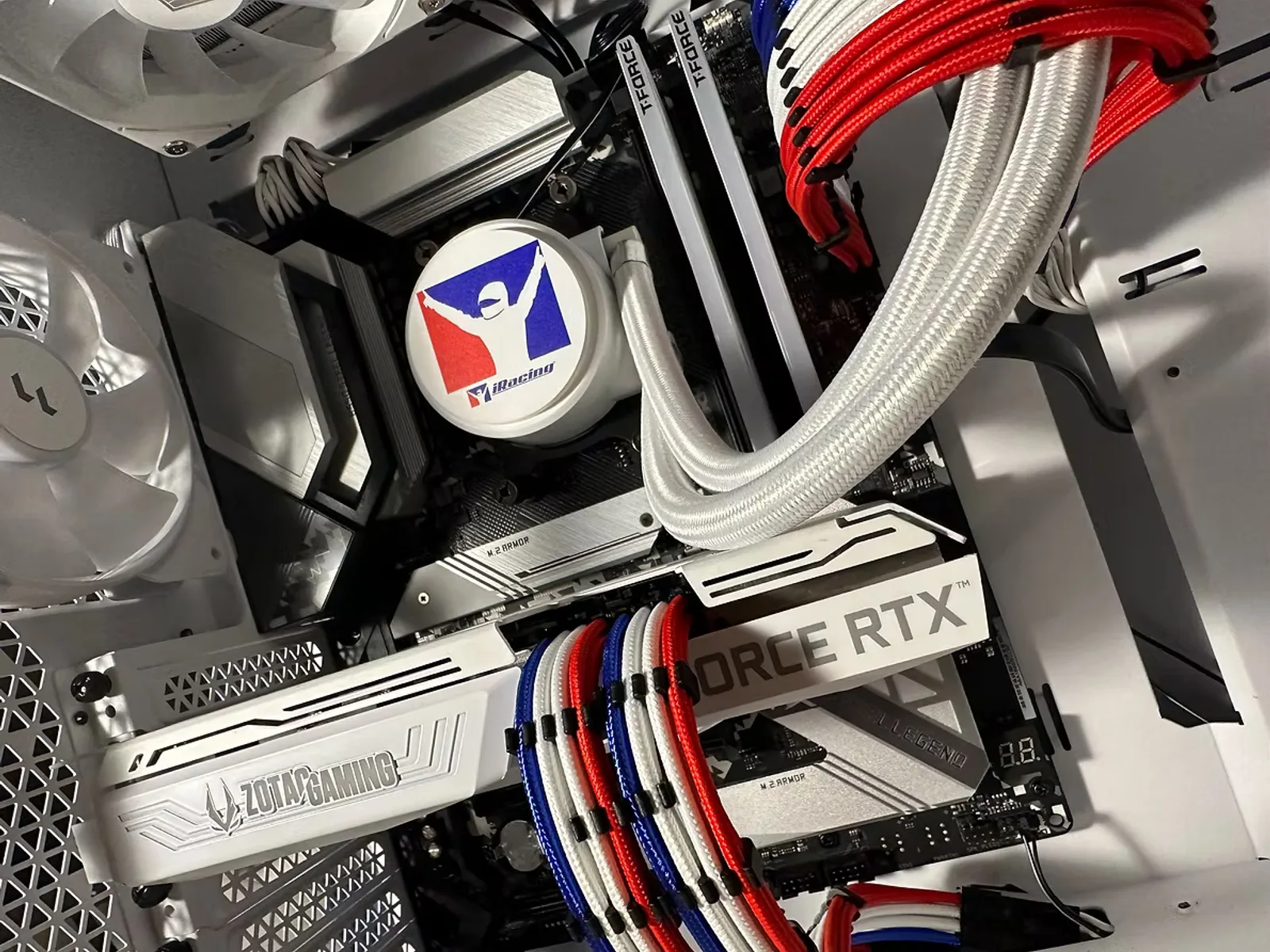 White PC interior with a TUF Gaming graphics card and red and white sleeved cables